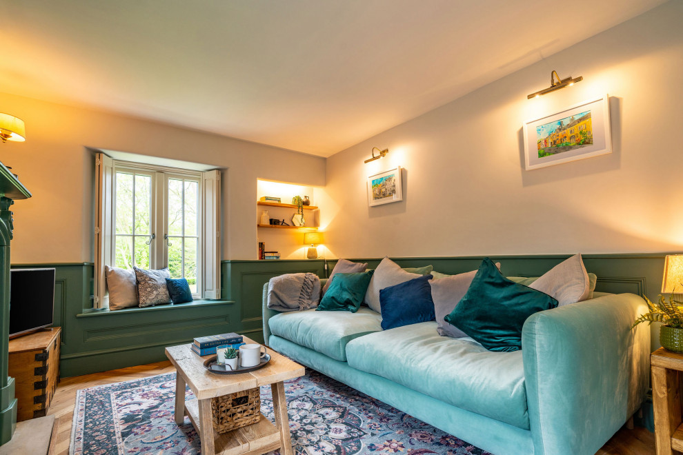 Design ideas for a medium sized country formal enclosed living room in Gloucestershire with green walls, dark hardwood flooring, a standard fireplace, a plastered fireplace surround, a wall mounted tv, brown floors, panelled walls and a dado rail.