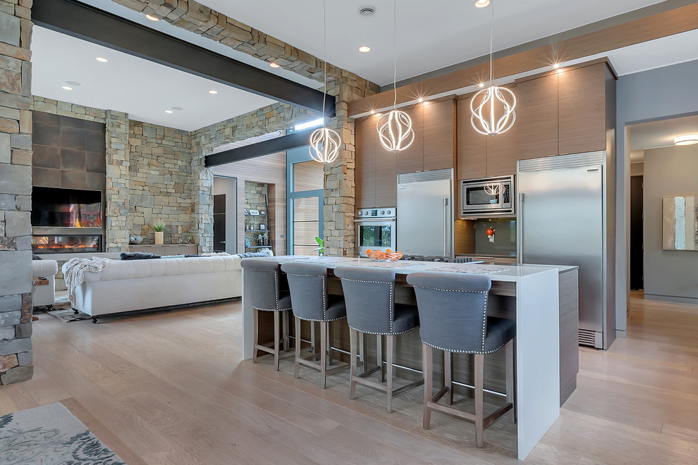 Photo of a large contemporary l-shaped open plan kitchen in Minneapolis with an undermount sink, flat-panel cabinets, medium wood cabinets, quartzite benchtops, grey splashback, stainless steel appliances, light hardwood floors, with island, window splashback and beige floor.