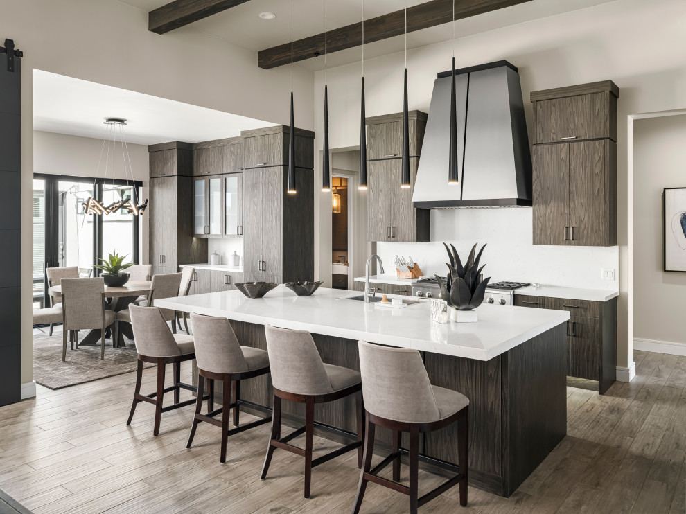 Large mediterranean l-shaped open plan kitchen in Phoenix with a submerged sink, flat-panel cabinets, brown cabinets, engineered stone countertops, white splashback, marble splashback, stainless steel appliances, ceramic flooring, an island, brown floors, white worktops and all types of ceiling.