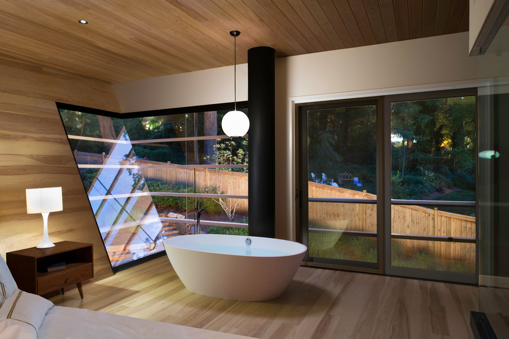 Photo of an expansive contemporary master wet room bathroom in San Francisco with a freestanding tub, light hardwood floors, white walls, brown floor, a hinged shower door, timber and vaulted.