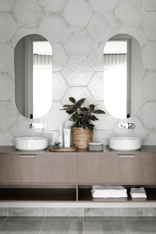 Photo of a mid-sized contemporary 3/4 bathroom in Melbourne with flat-panel cabinets, medium wood cabinets, gray tile, a vessel sink, grey floor, brown benchtops, a double vanity and a floating vanity.