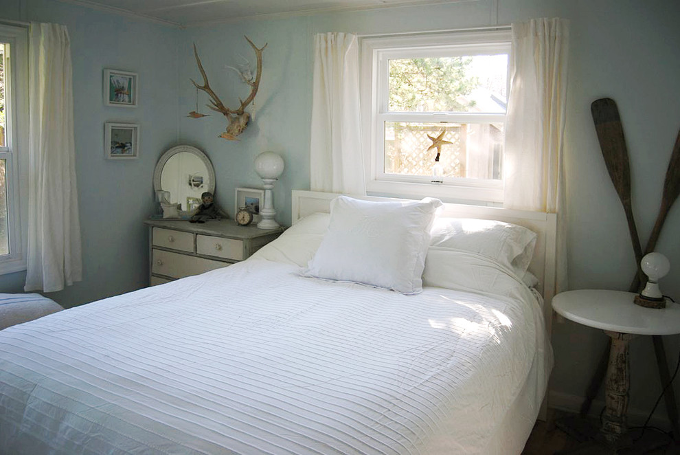 This is an example of a small beach style master bedroom in Portland with blue walls.