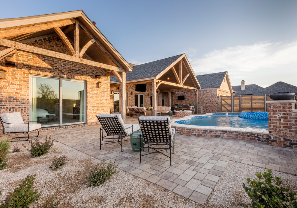 Large mountain style backyard brick and custom-shaped hot tub photo in Austin