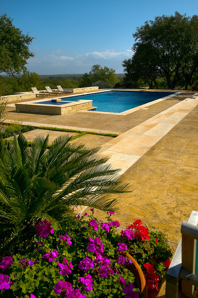 Expansive traditional backyard rectangular lap pool in Austin with concrete slab.