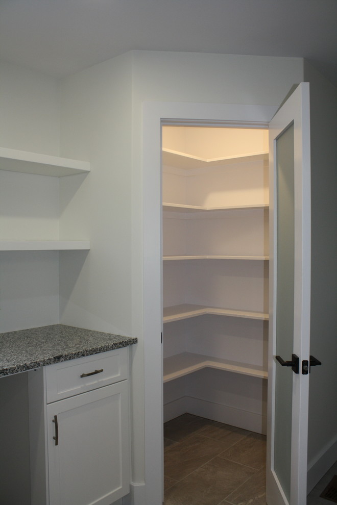 Photo of a small contemporary gender-neutral walk-in wardrobe in Other with open cabinets, white cabinets, ceramic floors and grey floor.