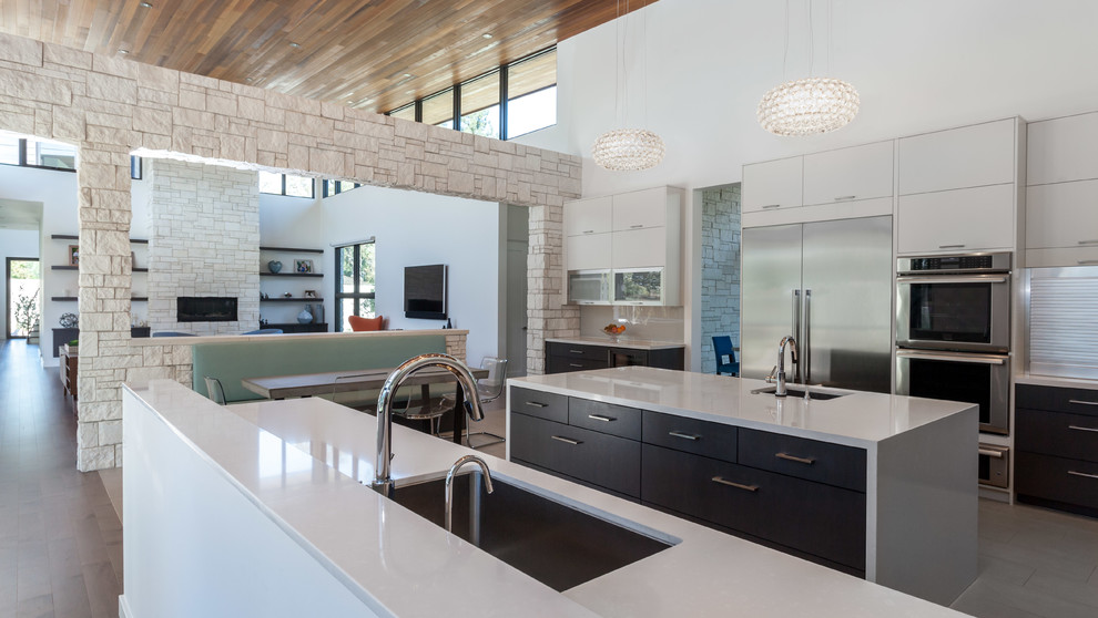 This is an example of a contemporary galley kitchen pantry in Sacramento with flat-panel cabinets, white cabinets, quartz benchtops, white splashback, glass sheet splashback, stainless steel appliances, ceramic floors and with island.