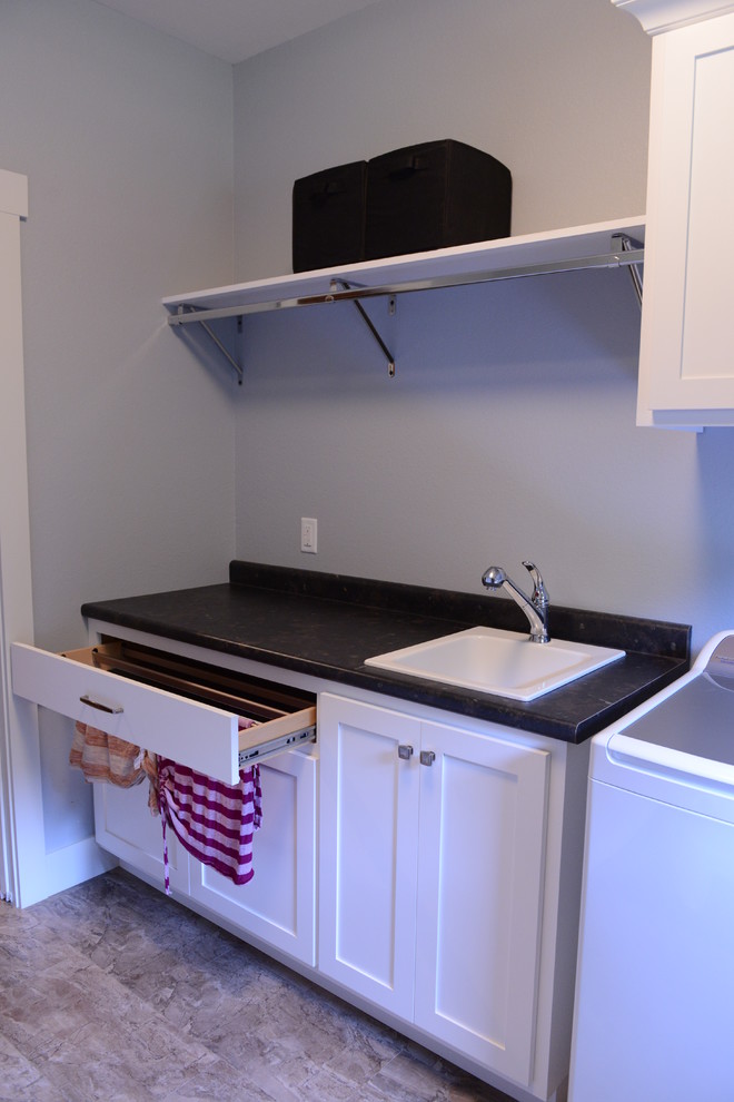 Example of a mid-sized transitional galley home design design in Chicago with a drop-in sink, shaker cabinets, white cabinets, laminate countertops and a side-by-side washer/dryer
