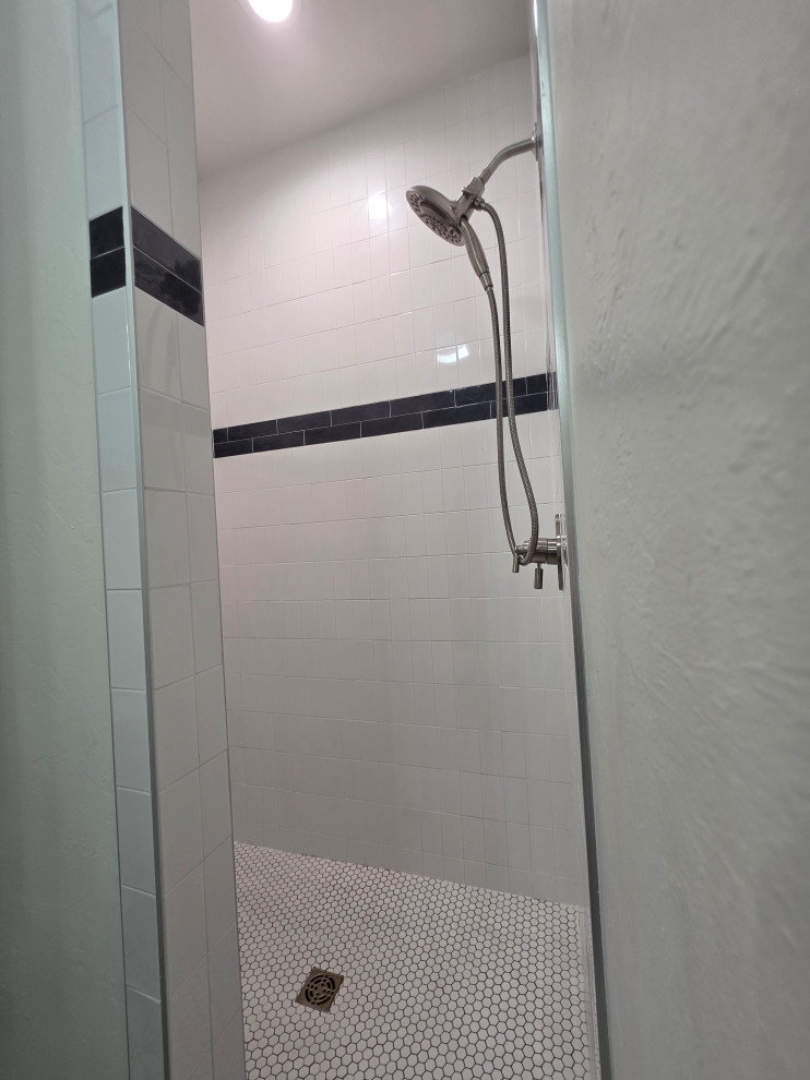 The shower has pebble floors & subway tile walls