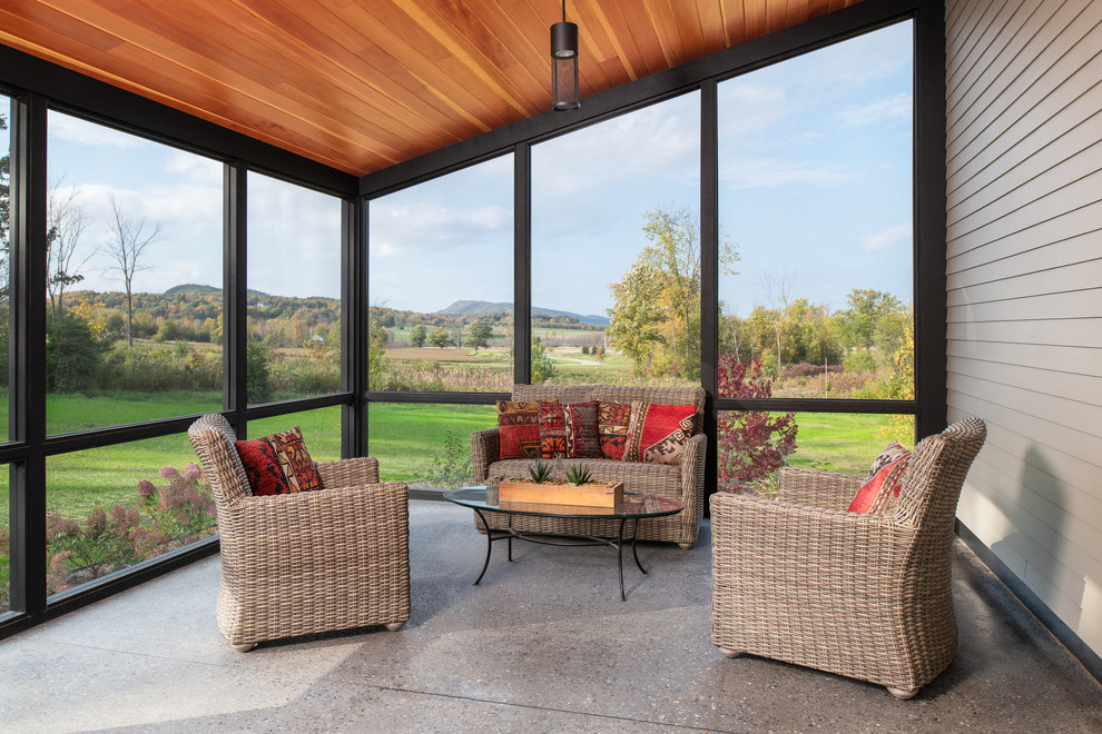 Inspiration for a mid-sized country side yard screened-in verandah in Burlington with concrete slab and a roof extension.