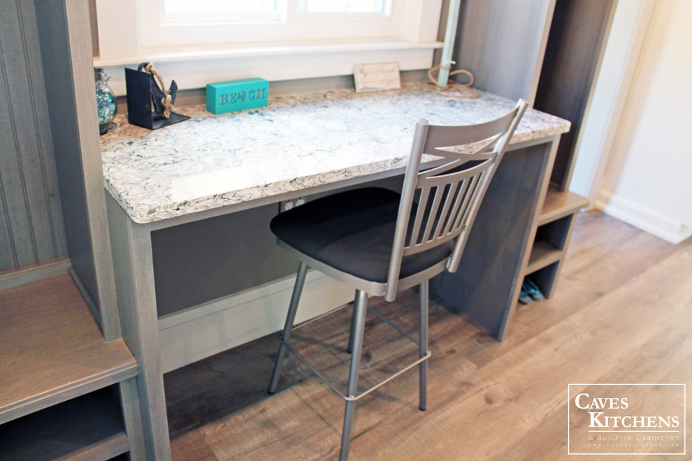 Inspiration for a small transitional l-shaped medium tone wood floor home design remodel in New York with a farmhouse sink, recessed-panel cabinets, gray cabinets, quartz countertops, black backsplash, subway tile backsplash, stainless steel appliances and no island