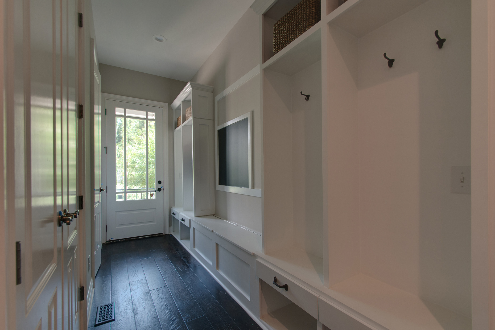 This second entry/vestibule to the home, was originally just an open hallway. By designing and incorporating  a customized cubby system for each family member, USI was able to create a space that enco