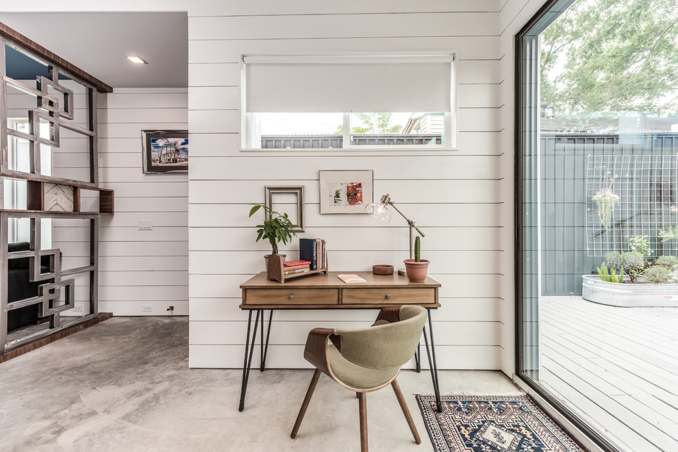 Small industrial home office in Houston with concrete floors, grey floor, white walls, no fireplace and a freestanding desk.