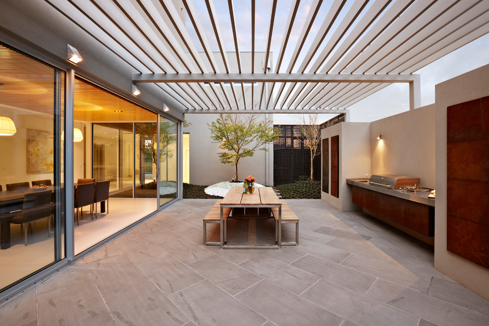 This is an example of a mid-sized contemporary backyard patio in Melbourne with tile and a pergola.