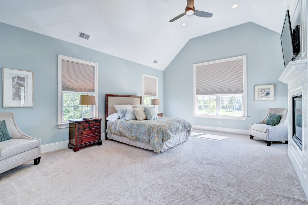 Expansive traditional master bedroom in Philadelphia with blue walls, carpet, a standard fireplace and a wood fireplace surround.
