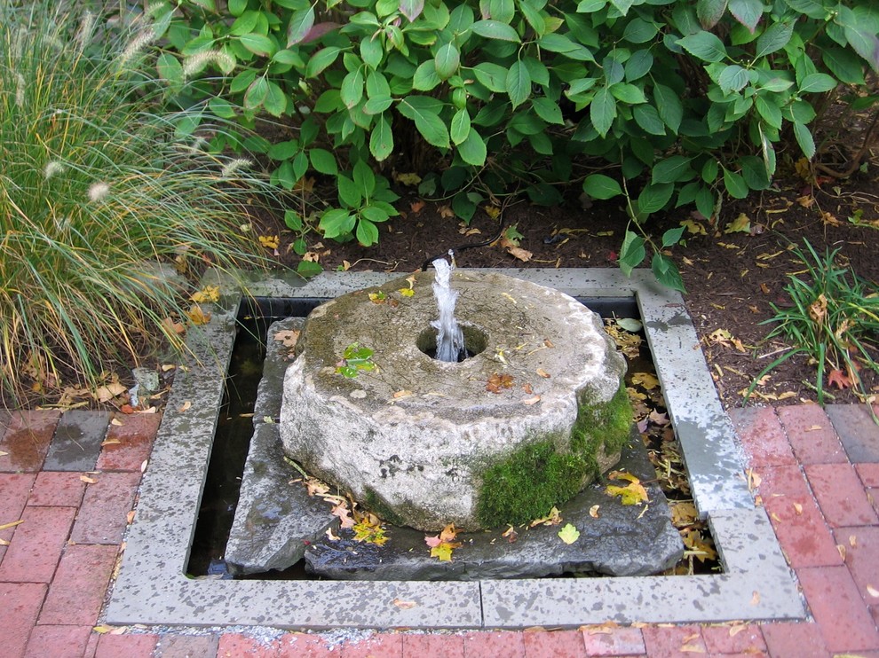 Inspiration for a large traditional backyard garden in Boston with a water feature and brick pavers.