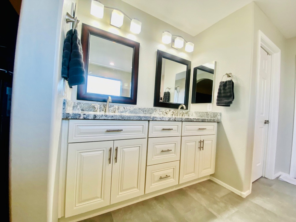 Large traditional ensuite bathroom in Phoenix with shaker cabinets, white cabinets, a walk-in shower, beige tiles, travertine tiles, beige walls, travertine flooring, a submerged sink, granite worktops, beige floors, an open shower, grey worktops, a wall niche, double sinks and a built in vanity unit.