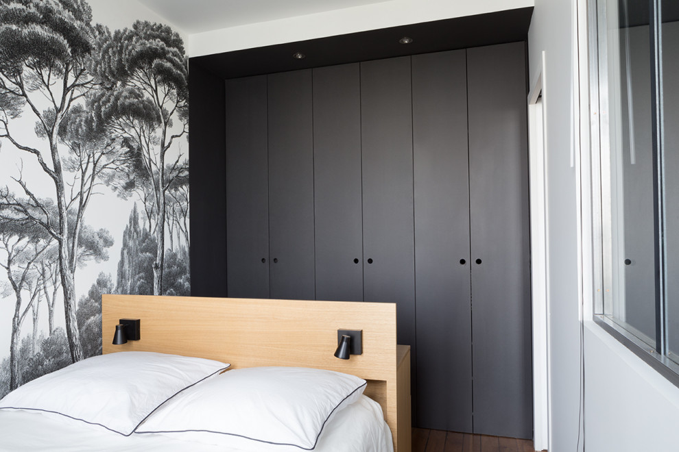 Photo of a small scandinavian bedroom in Paris with black walls, medium hardwood floors and beige floor.