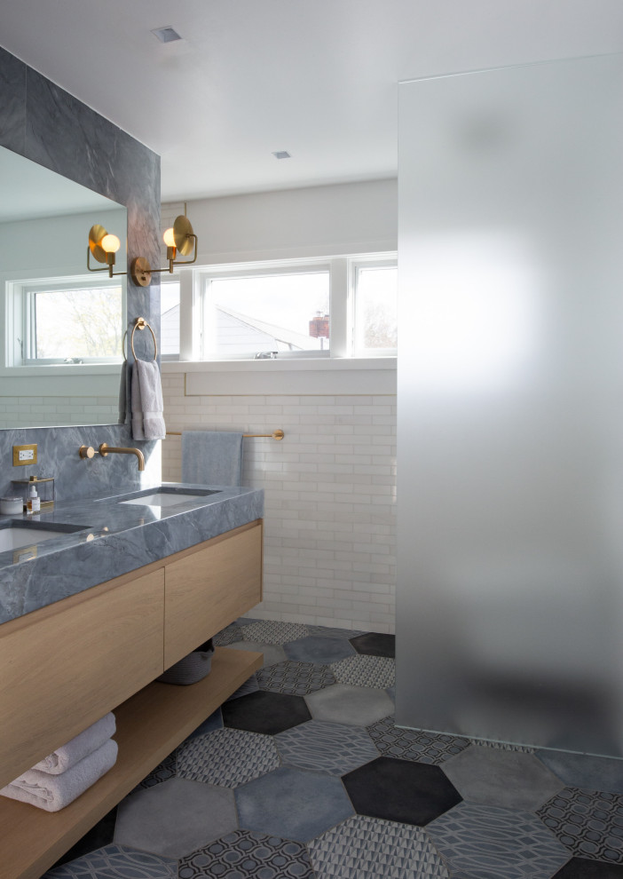 Design ideas for a large eclectic master bathroom in New York with flat-panel cabinets, light wood cabinets, a freestanding tub, white tile, subway tile, white walls, porcelain floors, an undermount sink, grey floor, a hinged shower door, grey benchtops, a double vanity and a built-in vanity.