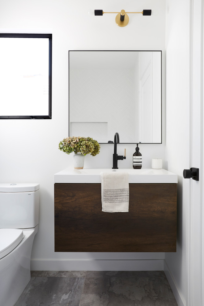 Inspiration for a mid-sized contemporary 3/4 bathroom in Los Angeles with flat-panel cabinets, dark wood cabinets, a two-piece toilet, grey floor, white walls and a console sink.
