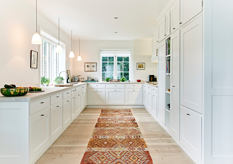 Inspiration for a large traditional u-shaped separate kitchen in Other with recessed-panel cabinets, white cabinets, wood benchtops, white splashback, panelled appliances, light hardwood floors, no island, beige floor and beige benchtop.