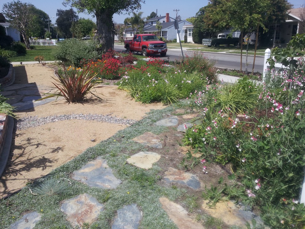 This is an example of a mid-sized front yard partial sun xeriscape for summer in Los Angeles with mulch.