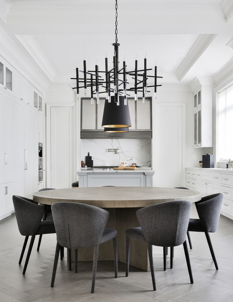 This is an example of a contemporary kitchen/dining combo in Toronto with white walls and grey floor.