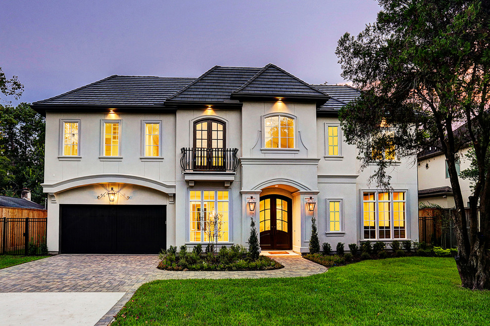 Photo of an arts and crafts two-storey stucco beige house exterior in Houston.