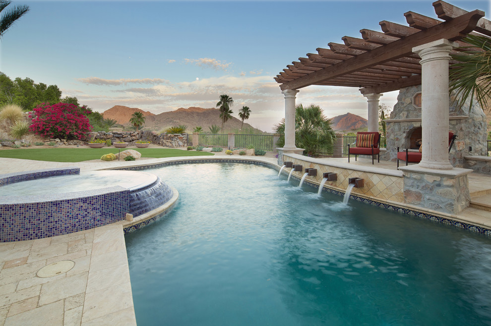 Design ideas for a large mediterranean backyard custom-shaped natural pool in Phoenix with a pool house and natural stone pavers.