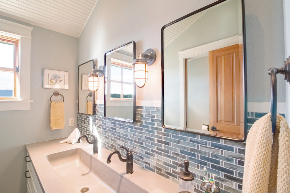 Inspiration for a transitional kids bathroom in Seattle with recessed-panel cabinets, white cabinets, an alcove shower, a two-piece toilet, blue tile, blue walls, porcelain floors, a trough sink and concrete benchtops.