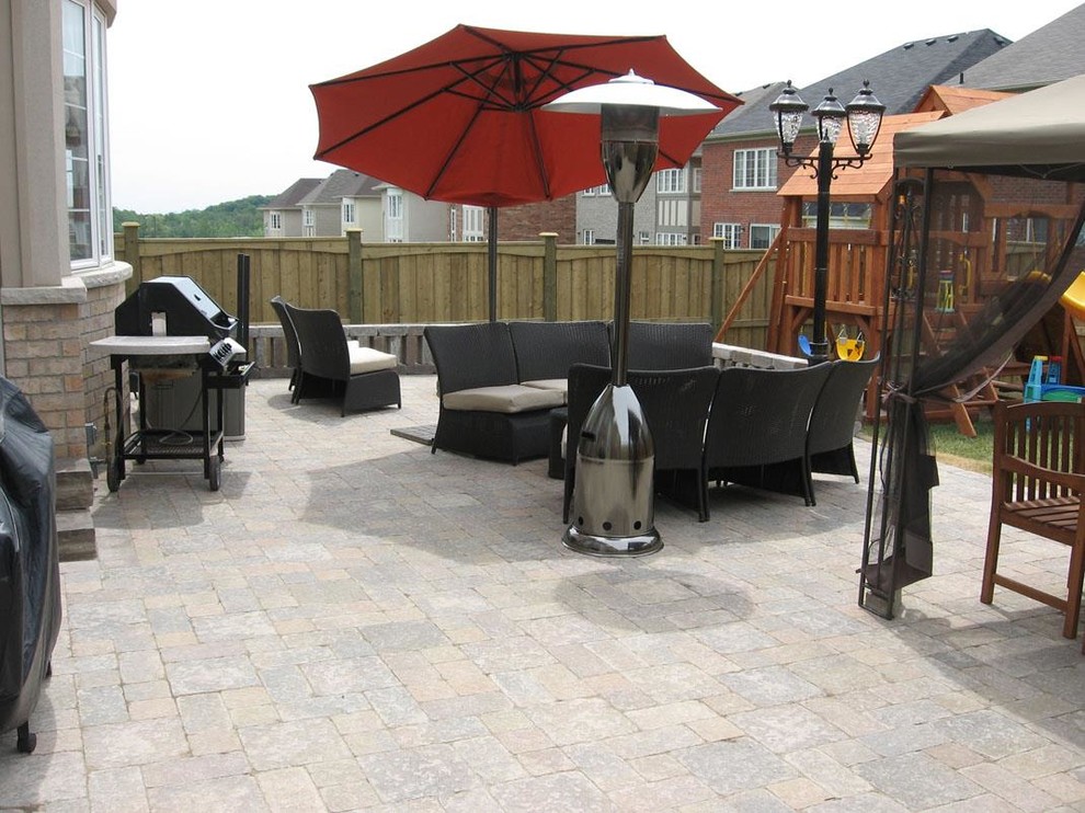 Photo of a small contemporary backyard patio in Toronto with an outdoor kitchen, natural stone pavers and no cover.