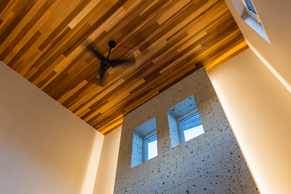 Aménagement d'un grand salon moderne ouvert avec un sol en bois brun, aucune cheminée, un téléviseur fixé au mur, un sol marron, un plafond en bois, du papier peint et un mur gris.