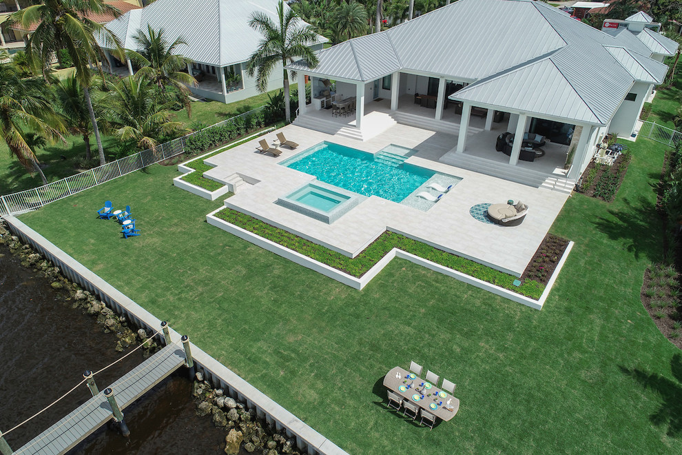 Large modern backyard rectangular lap pool in Miami with a hot tub and tile.