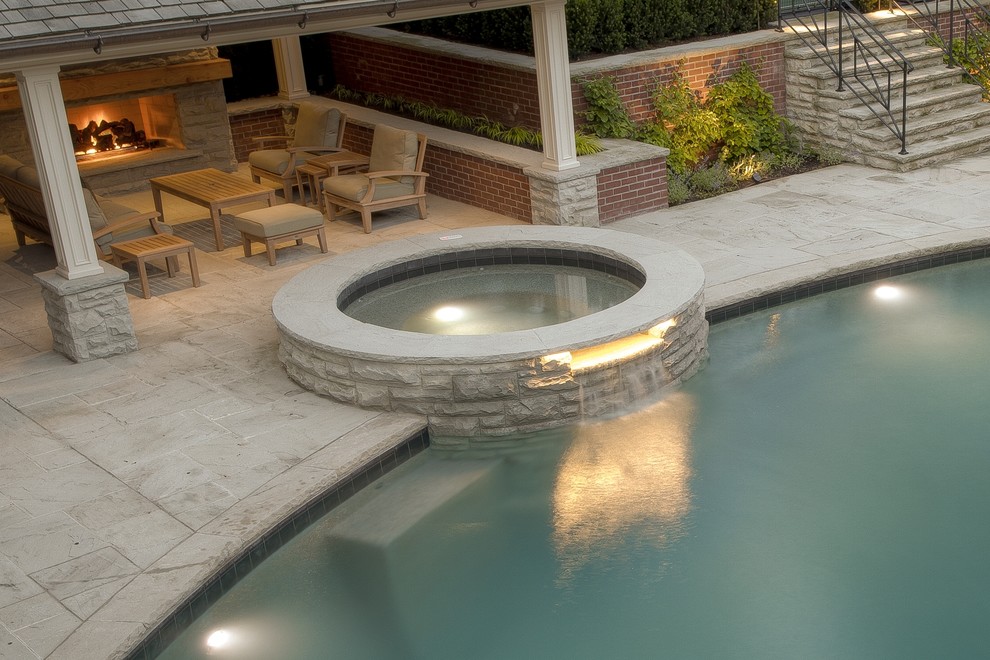 Mid-sized traditional backyard kidney-shaped pool in Toronto with a hot tub and natural stone pavers.