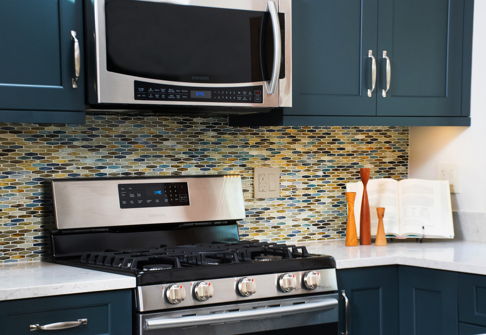 Open concept kitchen - mid-sized transitional u-shaped porcelain tile and white floor open concept kitchen idea in Chicago with an undermount sink, shaker cabinets, blue cabinets, quartz countertops, multicolored backsplash, glass tile backsplash, stainless steel appliances and a peninsula