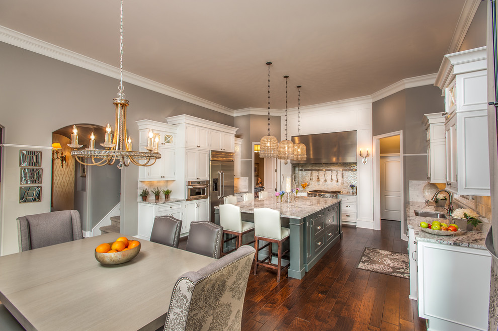 Eat-in kitchen - traditional u-shaped eat-in kitchen idea in Detroit with an undermount sink, shaker cabinets, white cabinets, white backsplash and stainless steel appliances