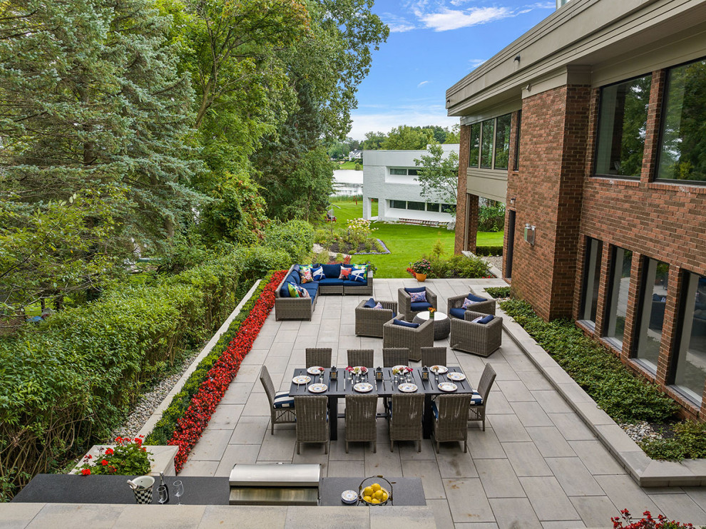 Идея дизайна: огромный двор на заднем дворе в стиле лофт с летней кухней и мощением тротуарной плиткой без защиты от солнца