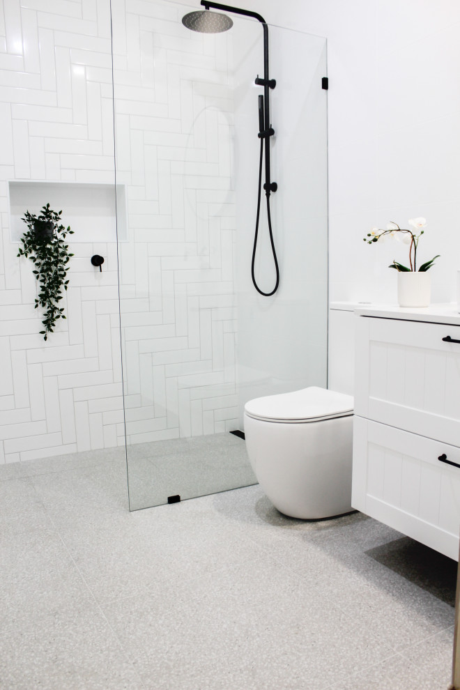 Photo of a mid-sized modern kids bathroom in Perth with shaker cabinets, white cabinets, an open shower, a one-piece toilet, white tile, ceramic tile, white walls, porcelain floors, a vessel sink, engineered quartz benchtops, white floor, an open shower, white benchtops, a single vanity and a floating vanity.