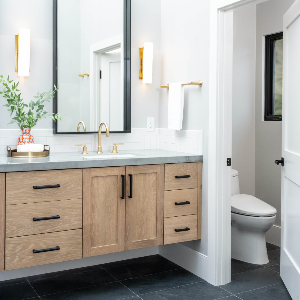 Design ideas for a large traditional wet room bathroom in San Francisco with shaker cabinets, medium wood cabinets, a one-piece toilet, white tiles, ceramic tiles, white walls, slate flooring, a submerged sink, engineered stone worktops, black floors, a hinged door, grey worktops, a shower bench, double sinks and a floating vanity unit.