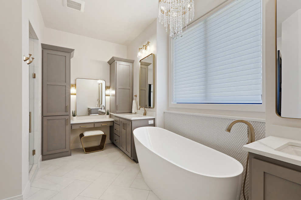 Example of a large transitional master white tile and porcelain tile porcelain tile, white floor and double-sink freestanding bathtub design with shaker cabinets, brown cabinets, white walls, quartz countertops, white countertops and a built-in vanity