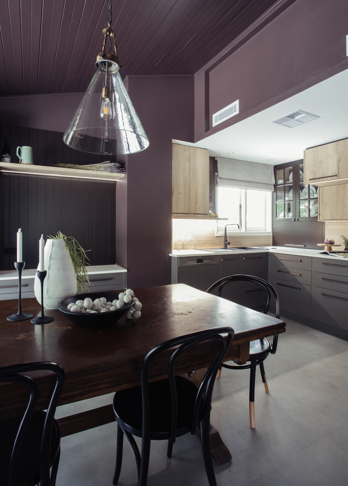 Photo of a small transitional l-shaped open plan kitchen in Sydney with a drop-in sink, flat-panel cabinets, light wood cabinets, solid surface benchtops, beige splashback, porcelain splashback, stainless steel appliances, linoleum floors, grey floor and beige benchtop.
