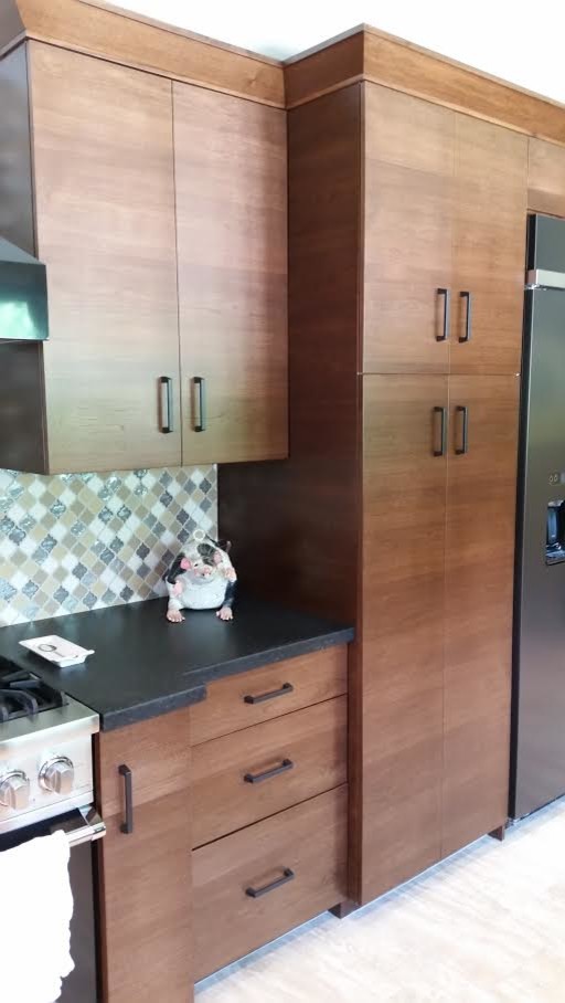 Open concept kitchen - mid-sized transitional light wood floor and beige floor open concept kitchen idea in Houston with flat-panel cabinets, medium tone wood cabinets, solid surface countertops, multicolored backsplash, glass tile backsplash, stainless steel appliances and no island