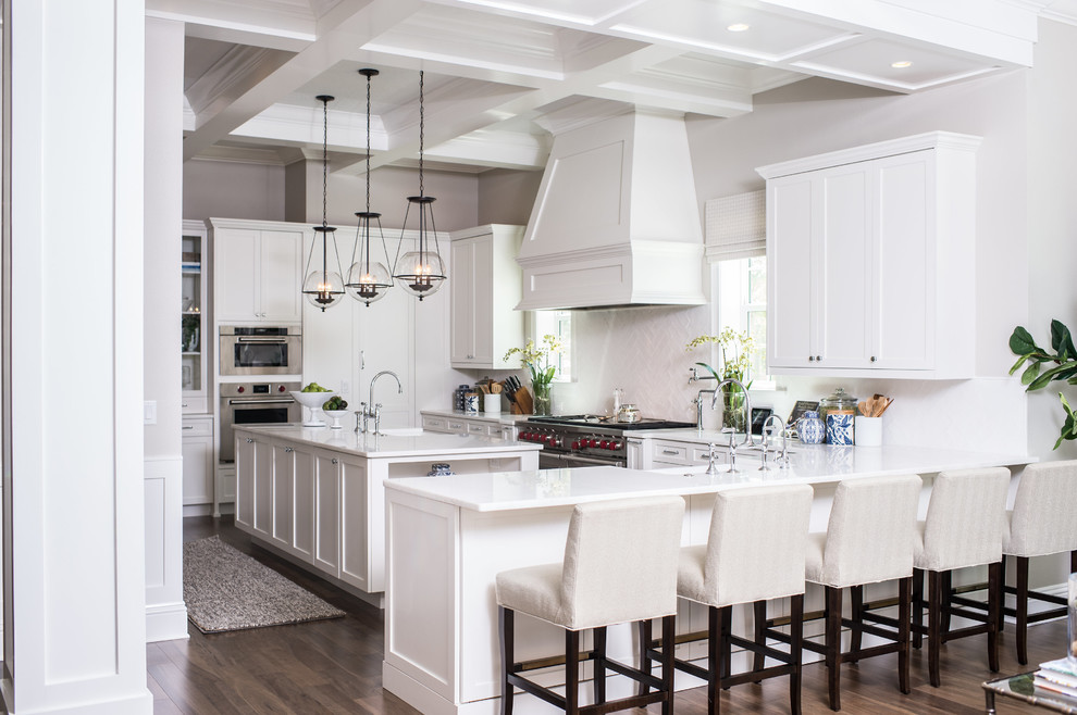 Inspiration for a large transitional open plan kitchen in Orlando with shaker cabinets, white cabinets, white splashback, with island, white benchtop, stainless steel appliances, dark hardwood floors and brown floor.