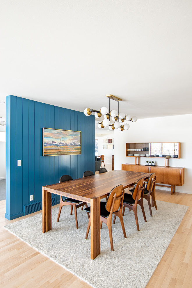 This is an example of a mid-sized midcentury kitchen/dining combo in Calgary with blue walls, light hardwood floors and planked wall panelling.