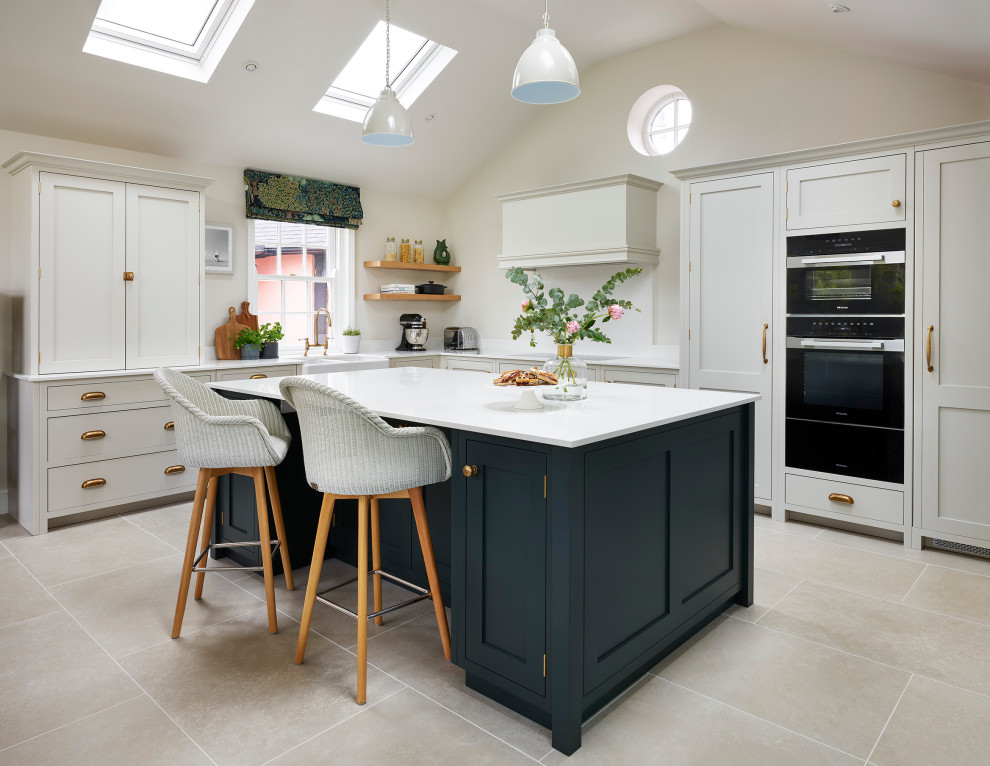 Design ideas for a traditional eat-in kitchen in Essex with a farmhouse sink, shaker cabinets, green cabinets, quartzite benchtops, white splashback, black appliances, porcelain floors, with island, grey floor, white benchtop and vaulted.