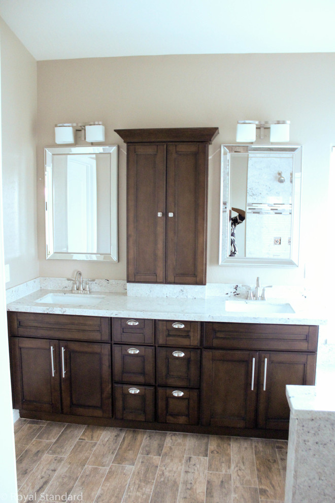 This is an example of a mid-sized traditional master bathroom in Phoenix with recessed-panel cabinets, dark wood cabinets, a drop-in tub, a double shower, a two-piece toilet, beige tile, beige walls, porcelain floors, an undermount sink, granite benchtops, brown floor, a hinged shower door and white benchtops.