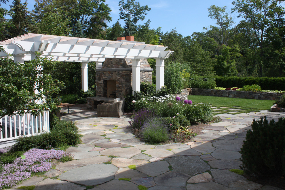 This is an example of a traditional patio in Grand Rapids with a fire feature and a pergola.