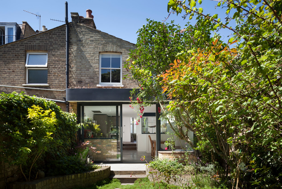 Photo of a contemporary backyard garden in London with concrete pavers.