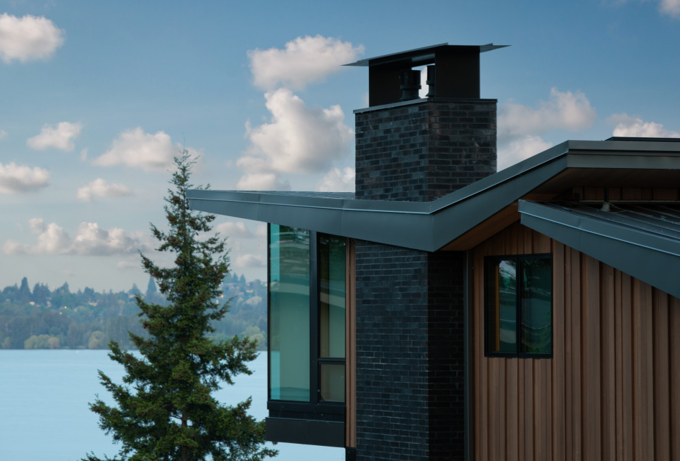 Exemple d'une grande façade de maison marron tendance en bois à niveaux décalés avec un toit papillon.