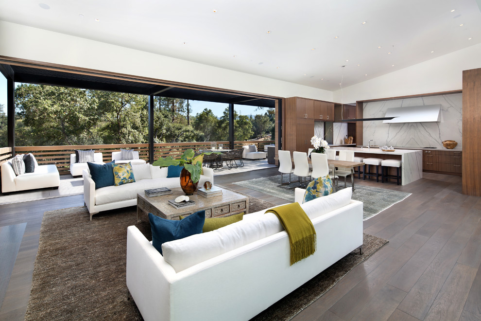 Photo of a contemporary open concept living room in San Francisco with white walls, dark hardwood floors and brown floor.