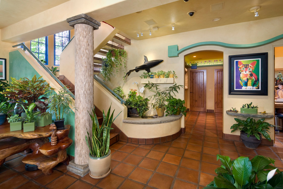 Eclectic entryway in Santa Barbara with beige walls, terra-cotta floors, a single front door and a medium wood front door.